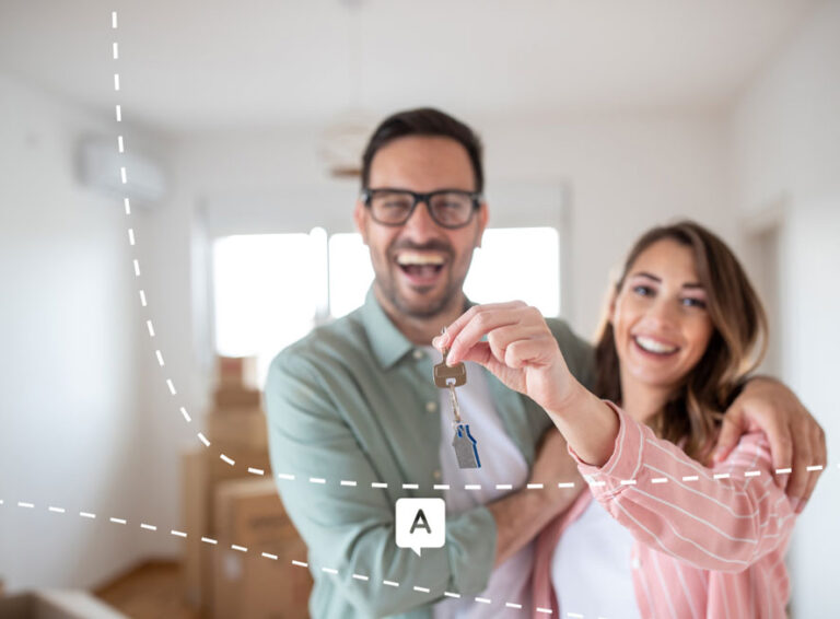 Couple souriant tenant la clé de leur nouveau logement, symbolisant l’achat d’une maison