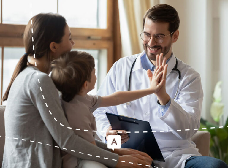 Médecin souriant donnant un high five à un enfant accompagné de sa mère lors d’une consultation médicale